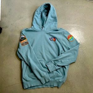 The North Face “Never Stop Exploring” light blue hoodie with patches